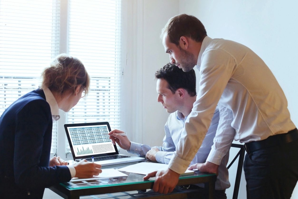 team working on a computer on UKG in an office